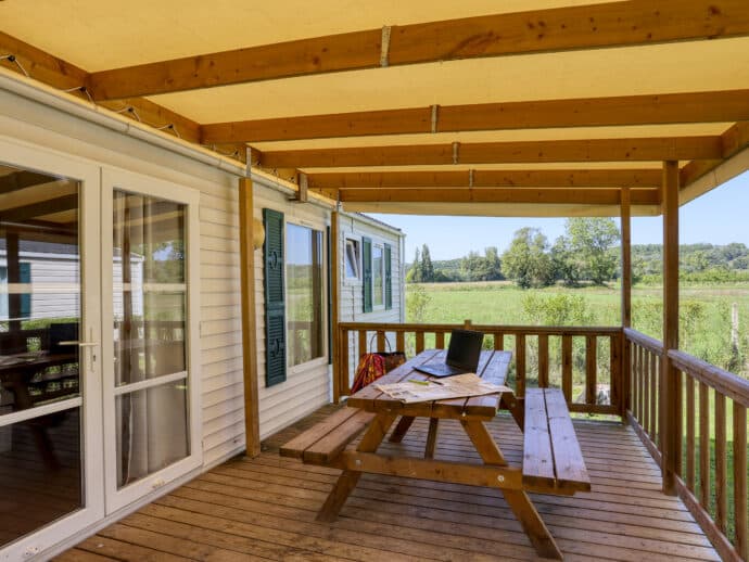 terrasse couverte avec table forestière surMobil home confort plus au camping la Salvinie